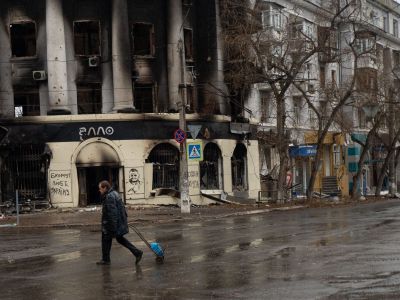 Житель Бахмута проходит мимо разрушенного здания в центре города. Фото: Madeleine Kelly / SOPA Images